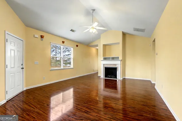 wooden floor in an empty room with a fireplace
