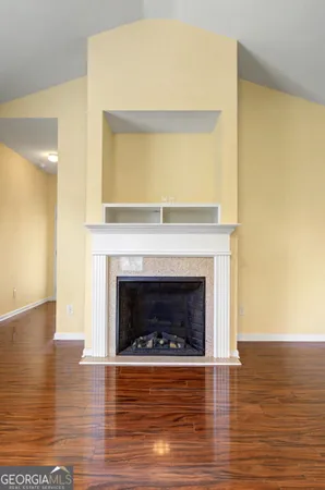 a living room with wooden floor and a fireplace