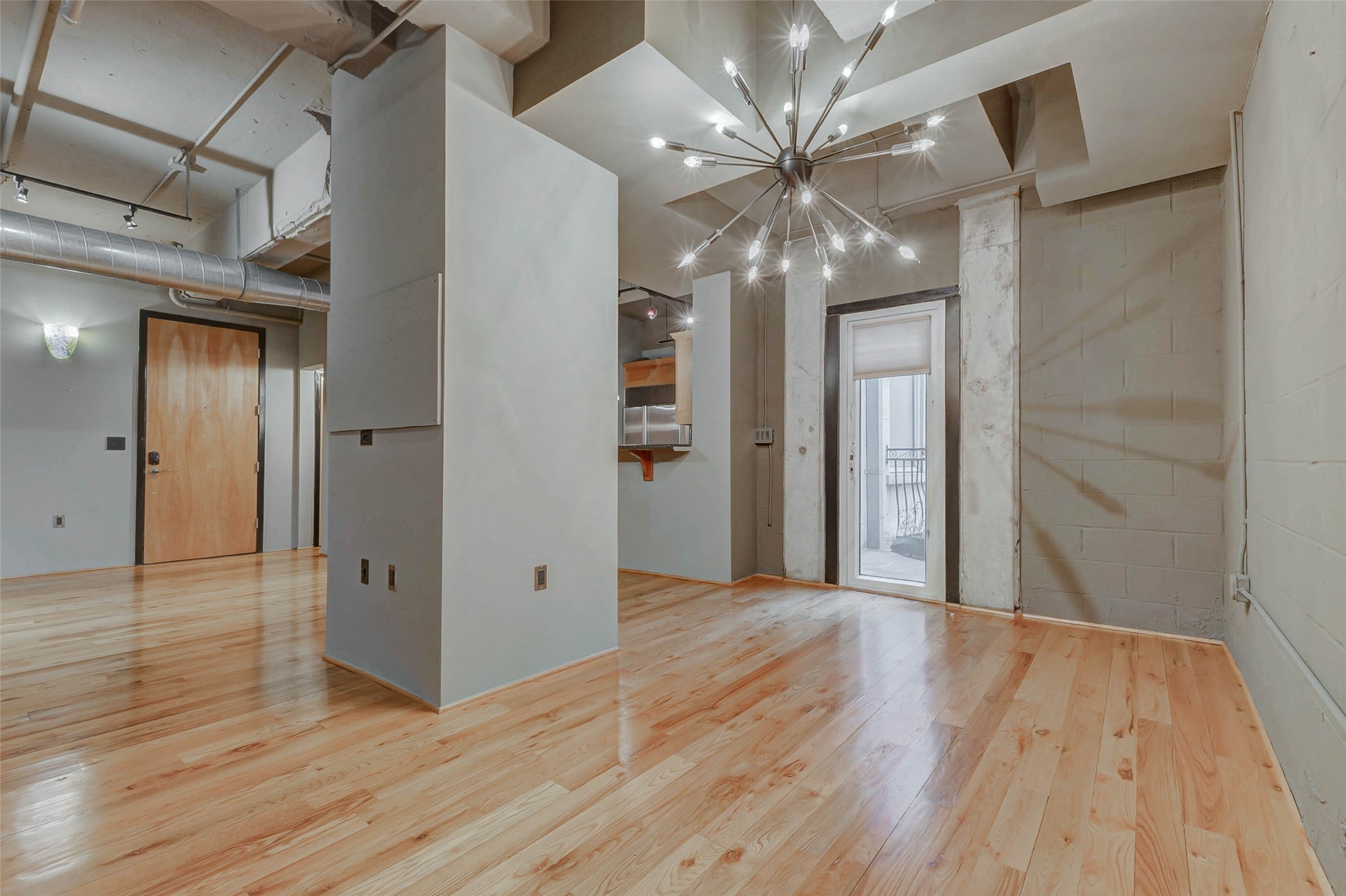 711 Main Street, Unit 505 Houston, TX 77002 - Photo 13 of 47 a view of a hallway with wooden floor and chandelier