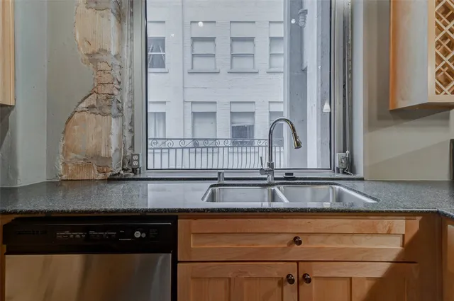 a kitchen with granite countertop white cabinets and black appliances