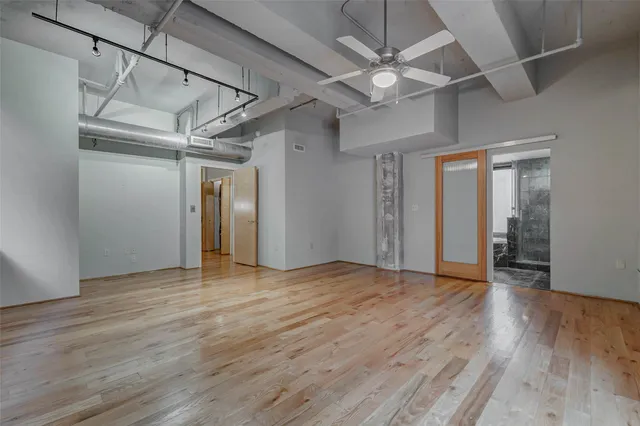 a view of an empty room with wooden floor
