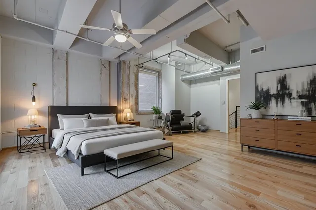 a spacious bedroom with a bed and a dresser