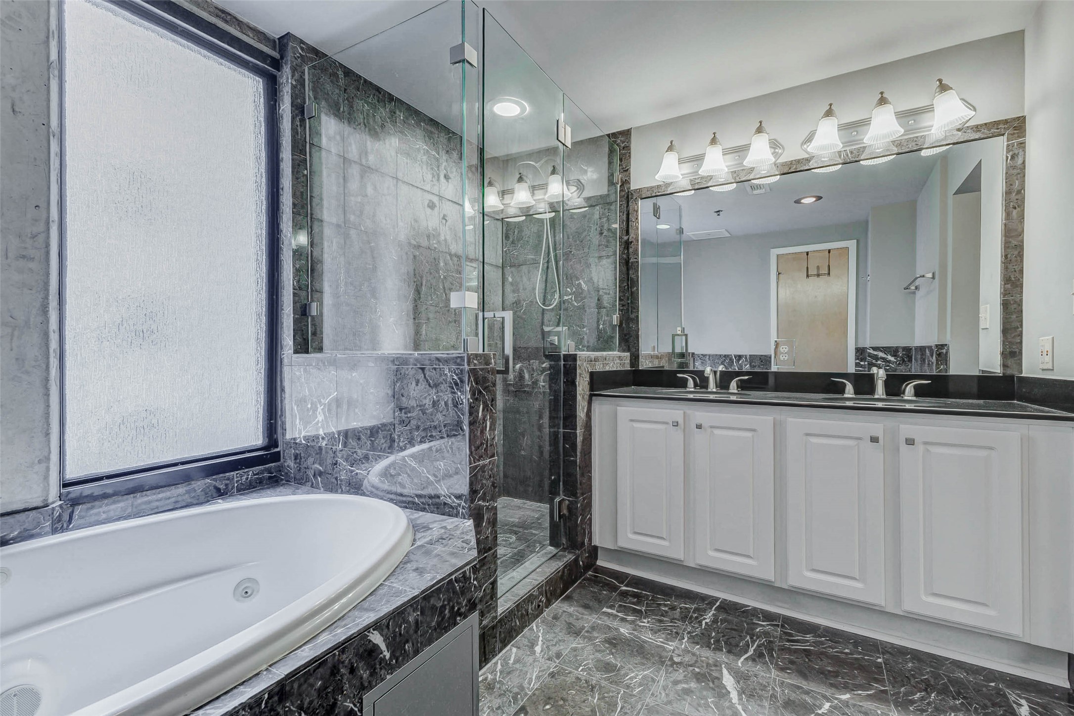 711 Main Street, Unit 505 Houston, TX 77002 - Photo 32 of 47 a bathroom with a tub a sink and mirror