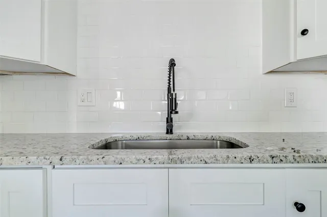 a kitchen with granite countertop white cabinets and a white counter top