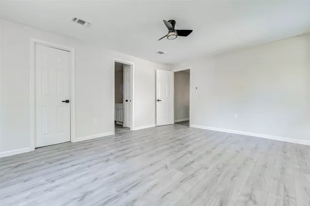 a view of an empty room with wooden floor