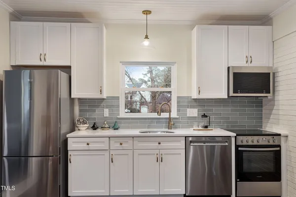 a kitchen with stainless steel appliances granite countertop a refrigerator sink and microwave