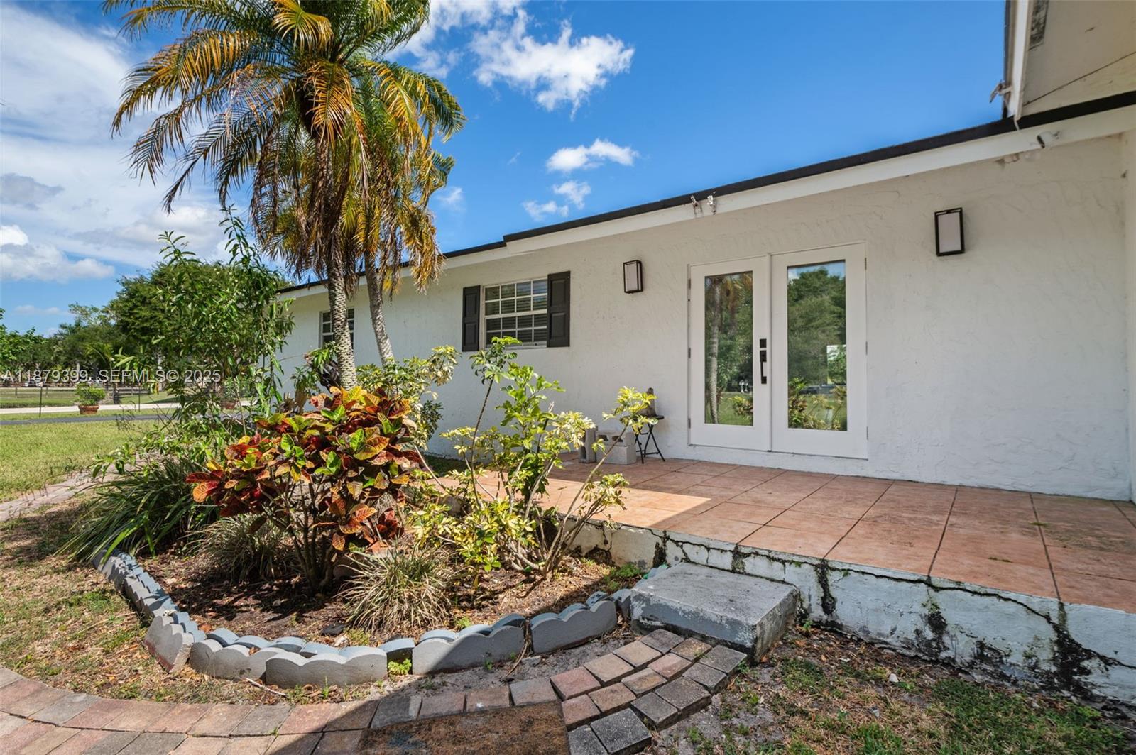 a front view of a house with a yard and potted plants