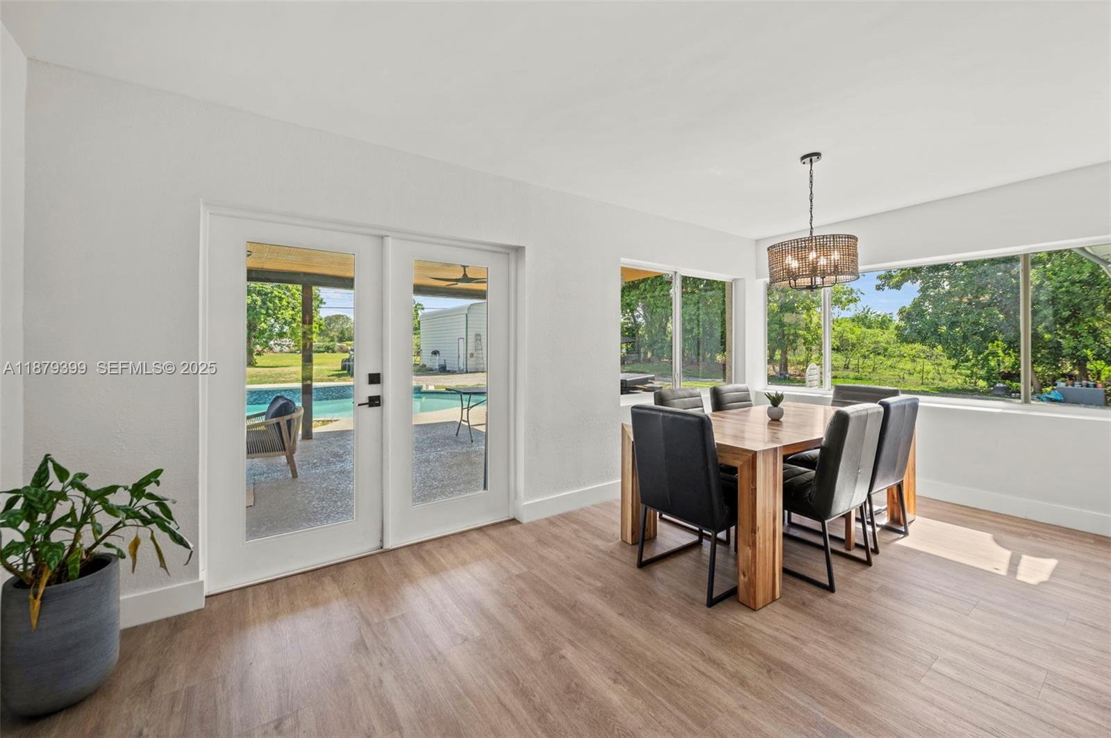 17611 Southwest 66th Street Southwest Ranches, FL 33331 - Photo 12 of 45 a dining room with furniture potted plants and wooden floor