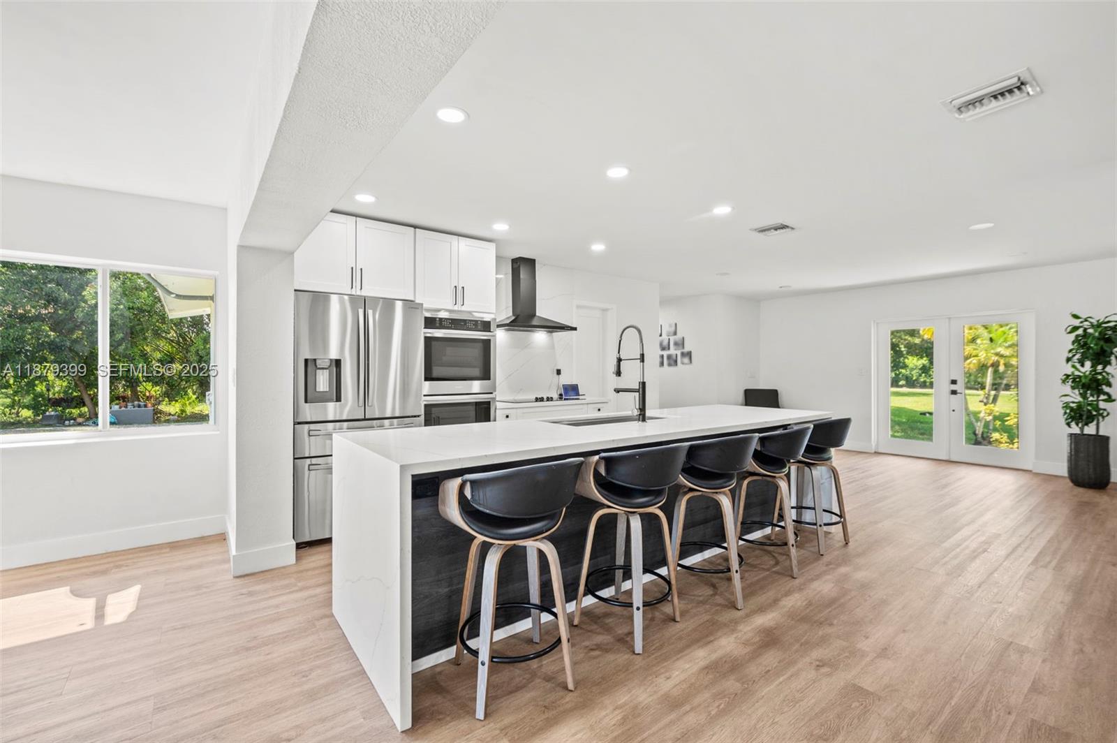 17611 Southwest 66th Street Southwest Ranches, FL 33331 - Photo 8 of 45 a kitchen with stainless steel appliances a table chairs refrigerator and microwave
