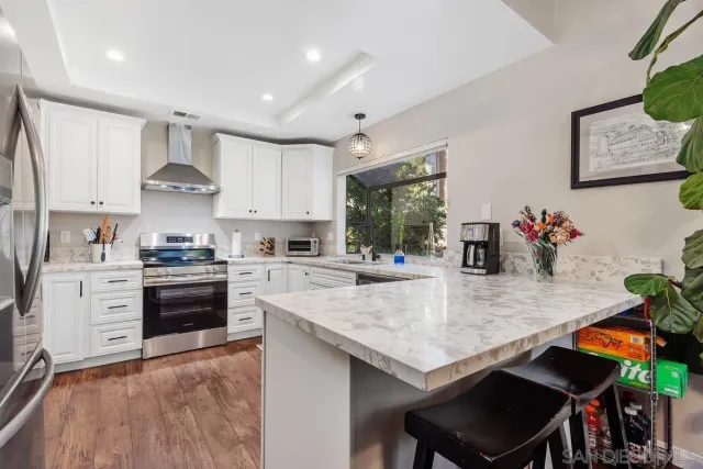a kitchen with stainless steel appliances granite countertop a stove refrigerator and cabinets