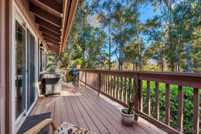 a view of a balcony with two chairs and wooden floor