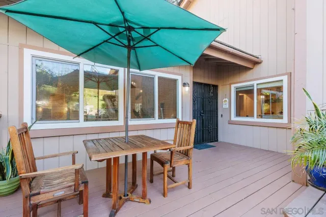 a view of a patio with table and chairs under an umbrella