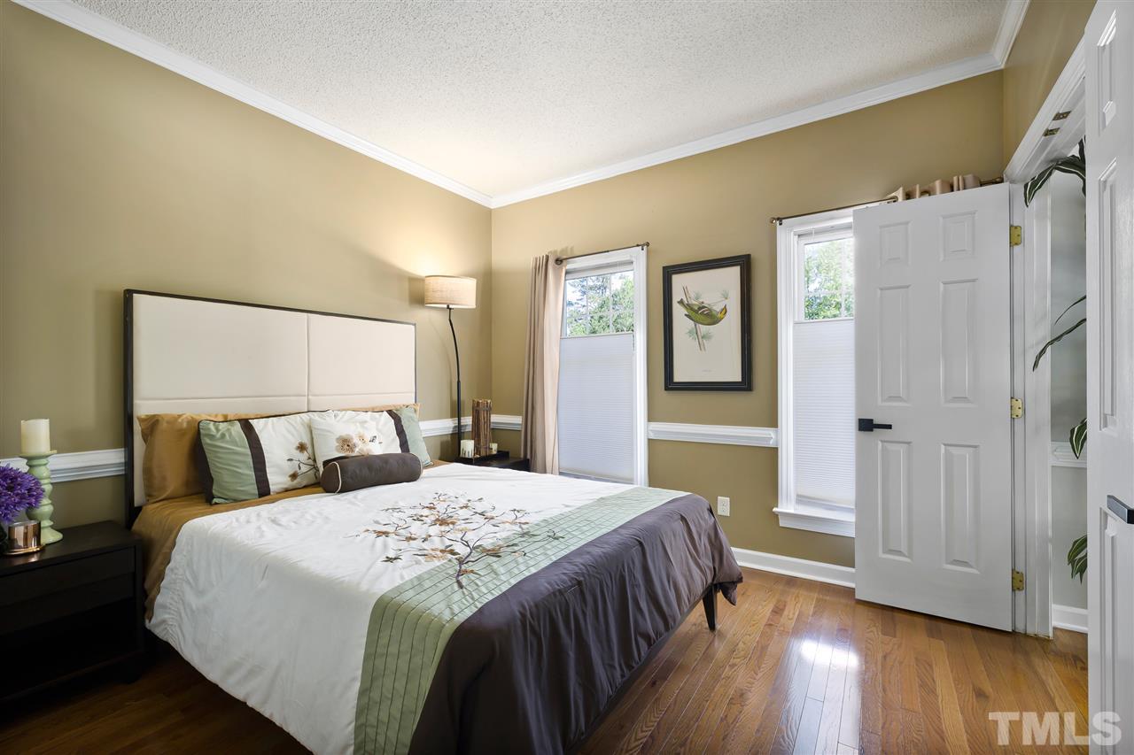 5633 Raddington Street Raleigh, NC 27613 - Photo 11 of 25 a bedroom with a bed and wooden floor