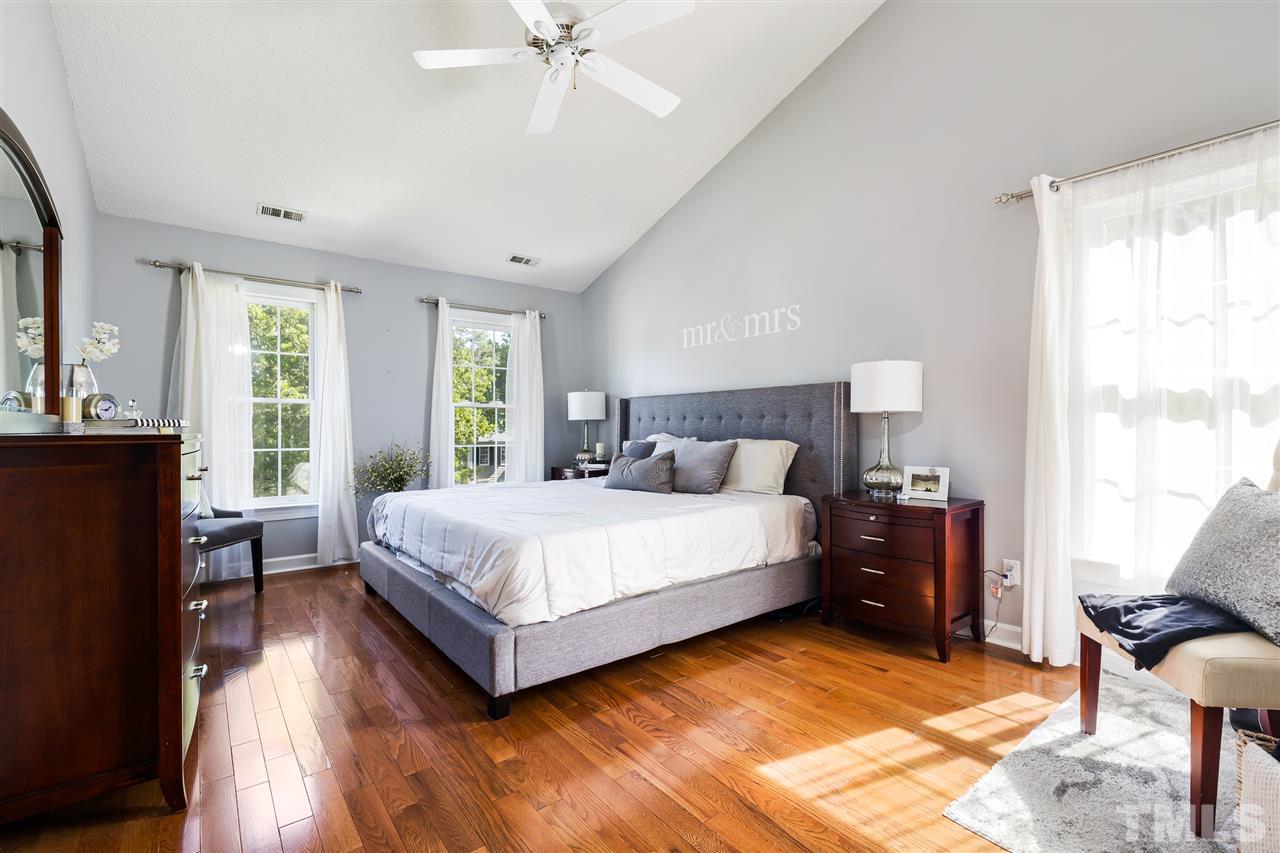 5633 Raddington Street Raleigh, NC 27613 - Photo 14 of 25 a bedroom with a bed and a chandelier