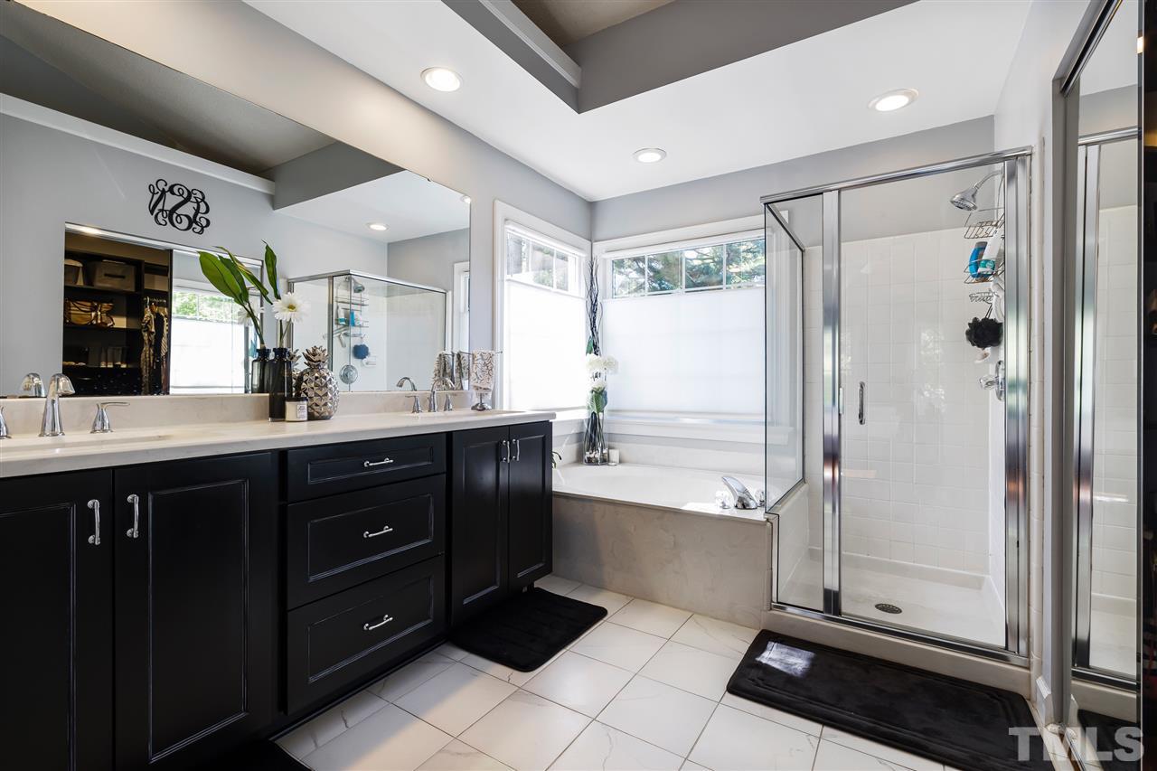 5633 Raddington Street Raleigh, NC 27613 - Photo 16 of 25 a bathroom with a double vanity sink mirror and shower