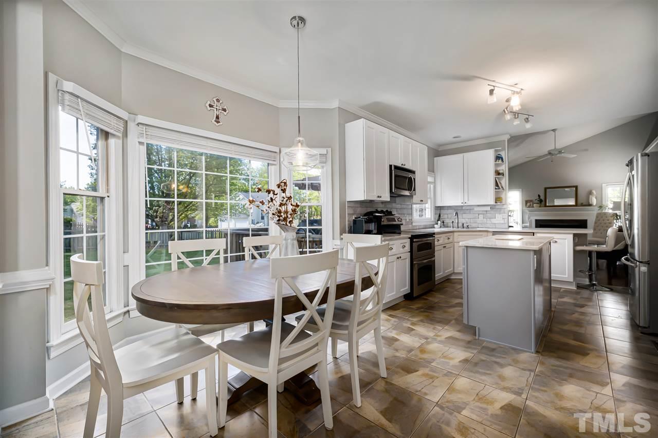 5633 Raddington Street Raleigh, NC 27613 - Photo 4 of 25 a dining room with kitchen island granite countertop furniture and a view of kitchen