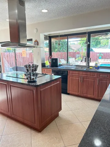 a kitchen with stainless steel appliances granite countertop wooden cabinets a sink and a large window