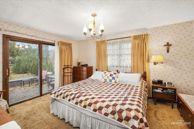 a bedroom with a large bed and a chandelier