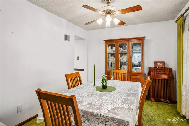 a view of dining room and livingroom with furniture wooden floor a flat screen tv and a chandelier
