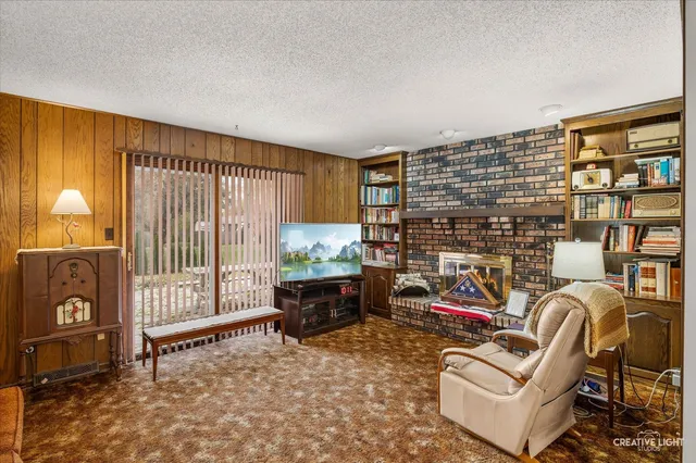 a living room with furniture a flat screen tv and a window