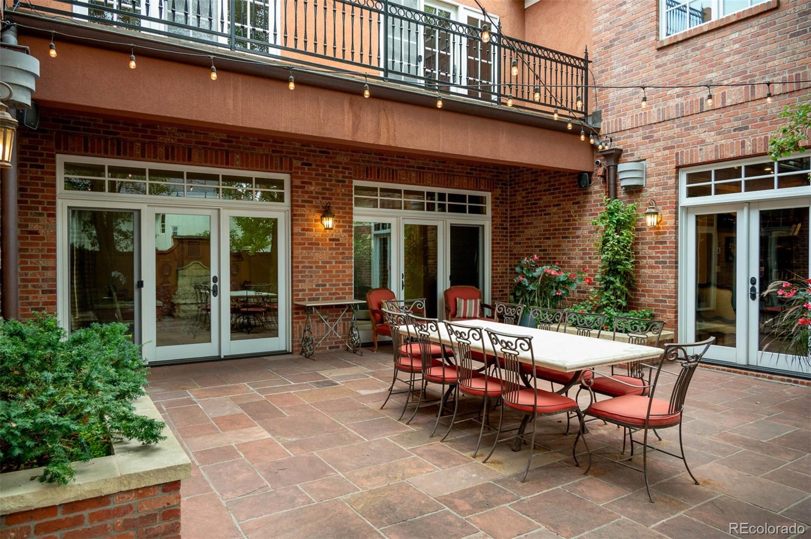 445 Madison Street Denver, CO 80206 - Photo 13 of 50 a view of a brick house with a chairs and table in a patio