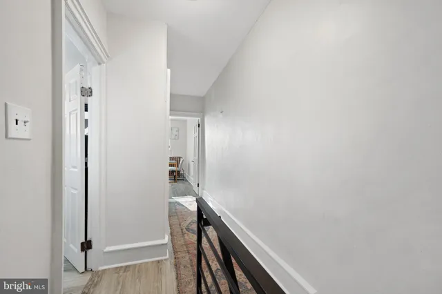 a view of a hallway with wooden floor and entryway