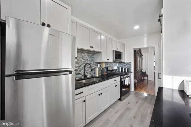 a kitchen with stainless steel appliances a refrigerator and a stove top oven