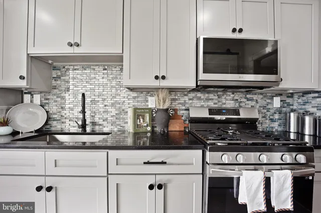 a kitchen with stainless steel appliances granite countertop a stove a microwave and cabinets