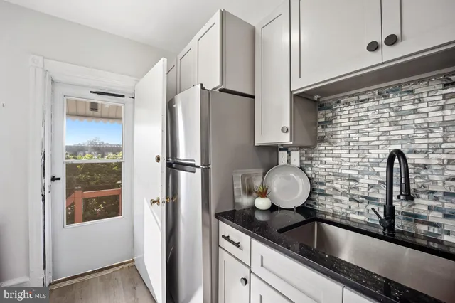 a kitchen with stainless steel appliances granite countertop a sink and a refrigerator