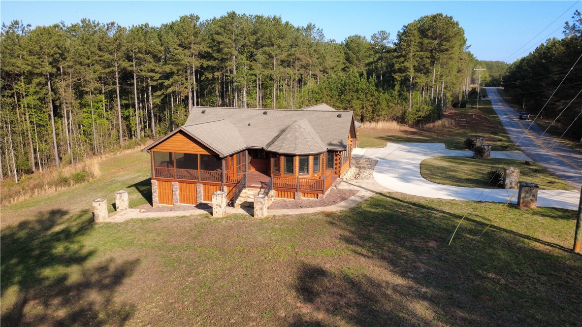 128 McAlister Road West Union, SC 29696 - Photo 1 of 40 A charming wood-clad home nestles amidst a verdant forest, featuring a circular drive and stone accents.