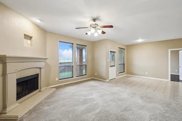 an empty room with windows and fireplace
