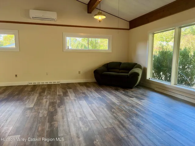 a living room with hardwood floor and a window