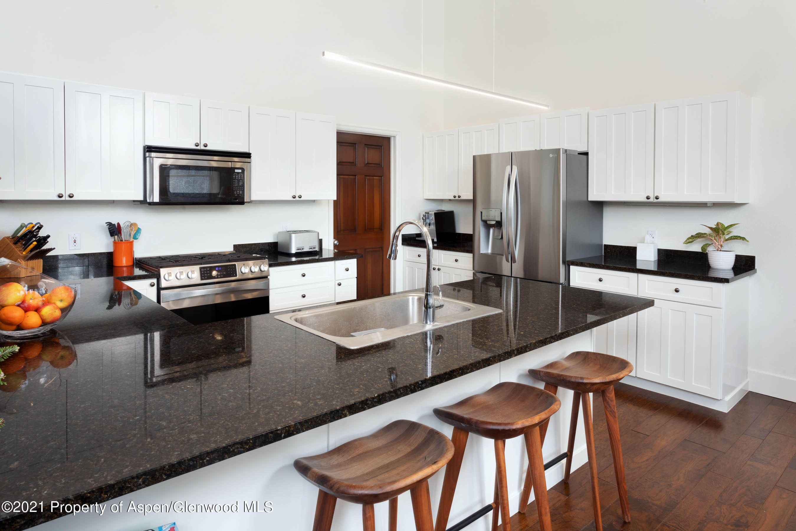 614 Evans Court Basalt, CO 81621 - Photo 14 of 34 a kitchen with stainless steel appliances granite countertop a table chairs microwave and sink