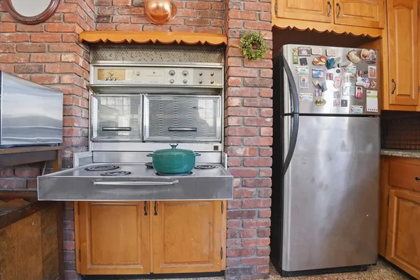 a kitchen with stainless steel appliances granite countertop a refrigerator and a stove