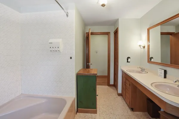 a bathroom with a tub sink and mirror