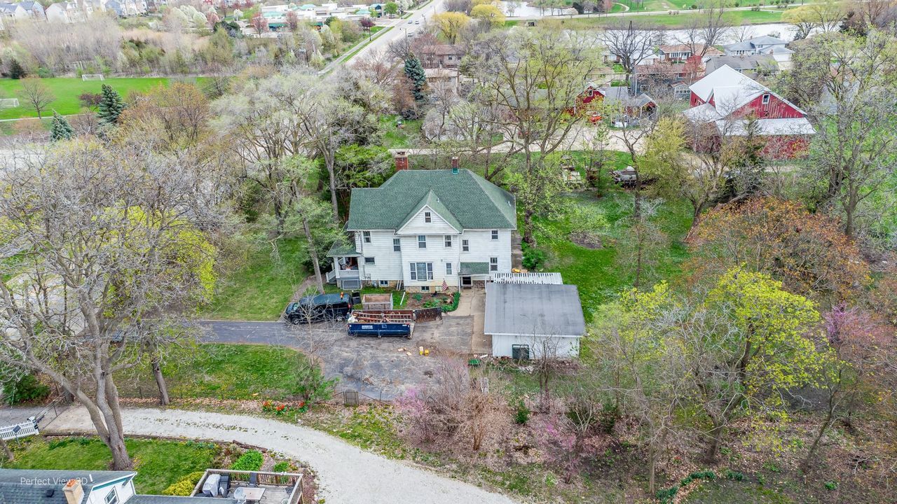 an aerial view of a house with yard and green space