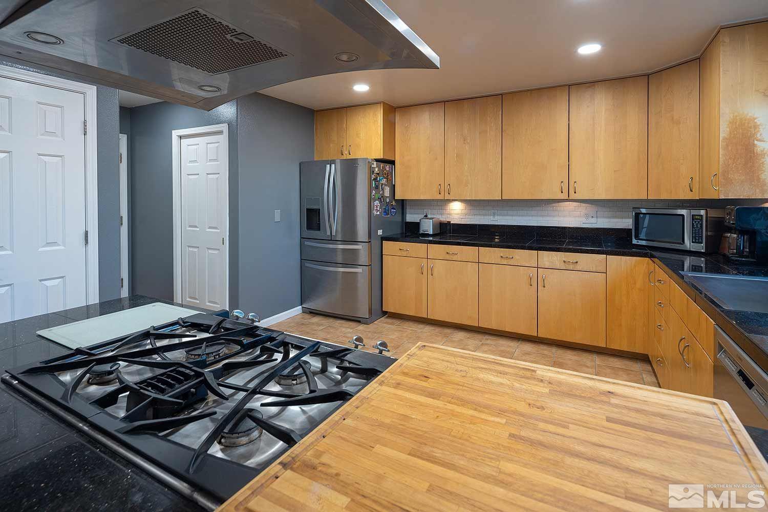 21590 Delta Drive Reno, NV 89521 - Photo 5 of 36 a kitchen with stainless steel appliances granite countertop a stove and a refrigerator