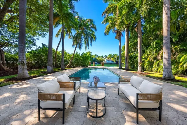 a view of patio with couches table and chairs potted plants and palm tree