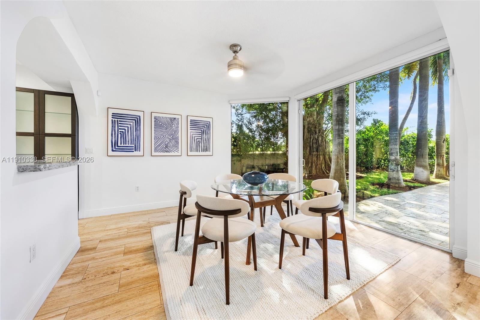 6300 Allison Road Miami Beach, FL 33141 - Photo 16 of 43 a dining room with furniture a rug and a floor to ceiling window