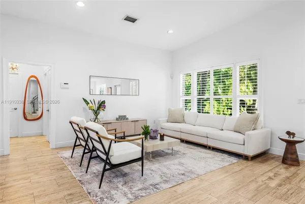 a living room with furniture a window and a potted plant