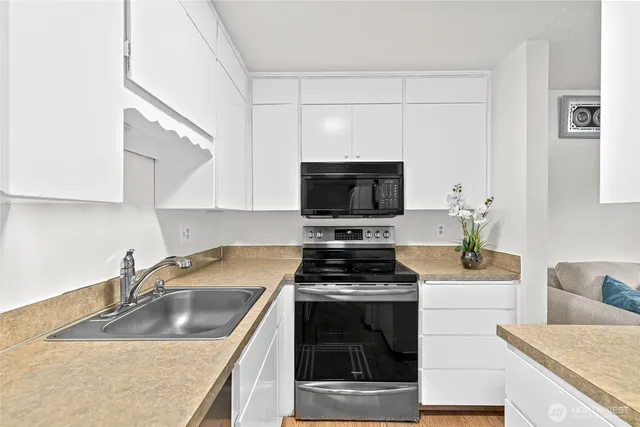 a kitchen with a sink stove and microwave