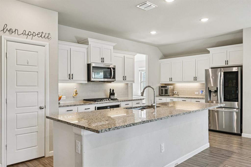 312 Scenic Point Drive Princeton, TX 75407 - Photo 14 of 40 a kitchen with stainless steel appliances granite countertop a sink stove and refrigerator