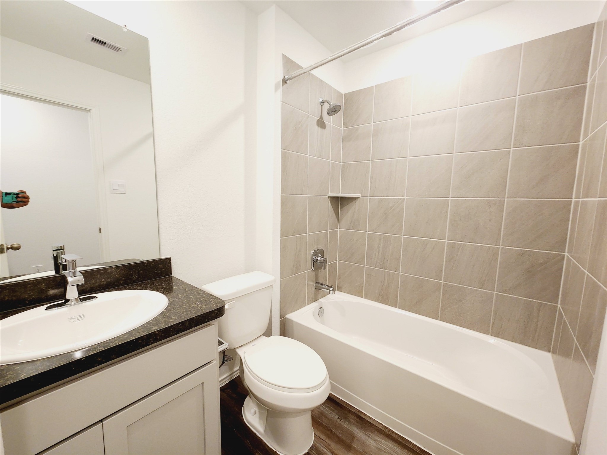 6043 Canyon Dawn Drive Spring, TX 77373 - Photo 23 of 31 This bathroom features a modern design with a tiled shower and tub combo, a sleek vanity with a dark countertop, and a clean white color scheme.