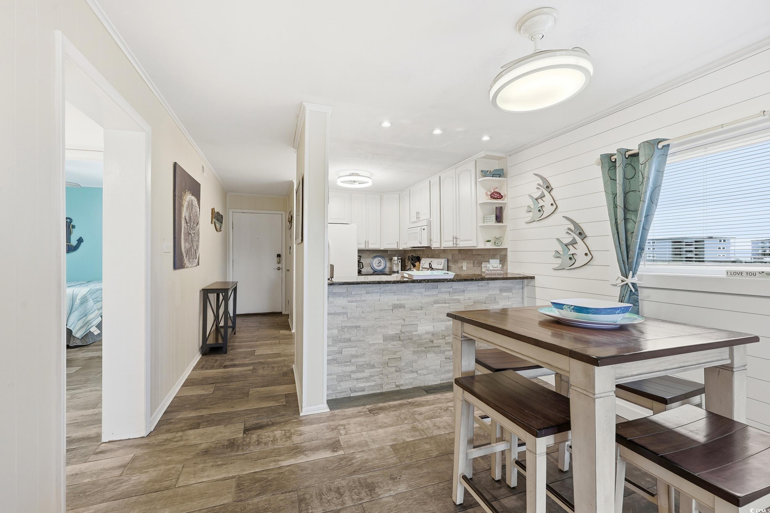 9501 Shore Drive, Unit A208 Myrtle Beach, SC 29572 - Photo 12 of 29 Kitchen with white cabinetry, open shelves, wood finished floors, decorative backsplash, and white appliances