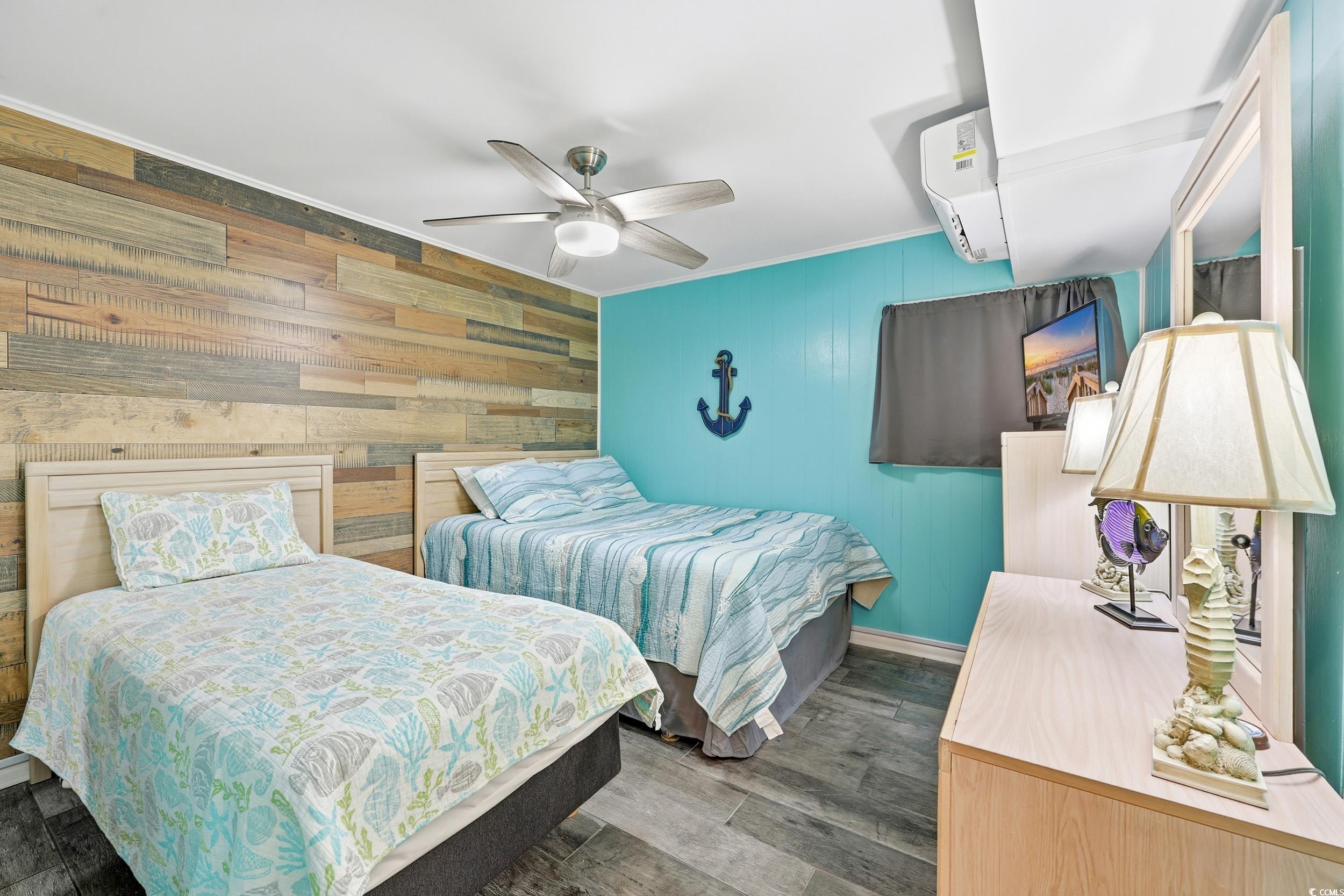 9501 Shore Drive, Unit A208 Myrtle Beach, SC 29572 - Photo 15 of 29 Bedroom with wooden walls, ceiling fan, wood finished floors, and a wall mounted AC