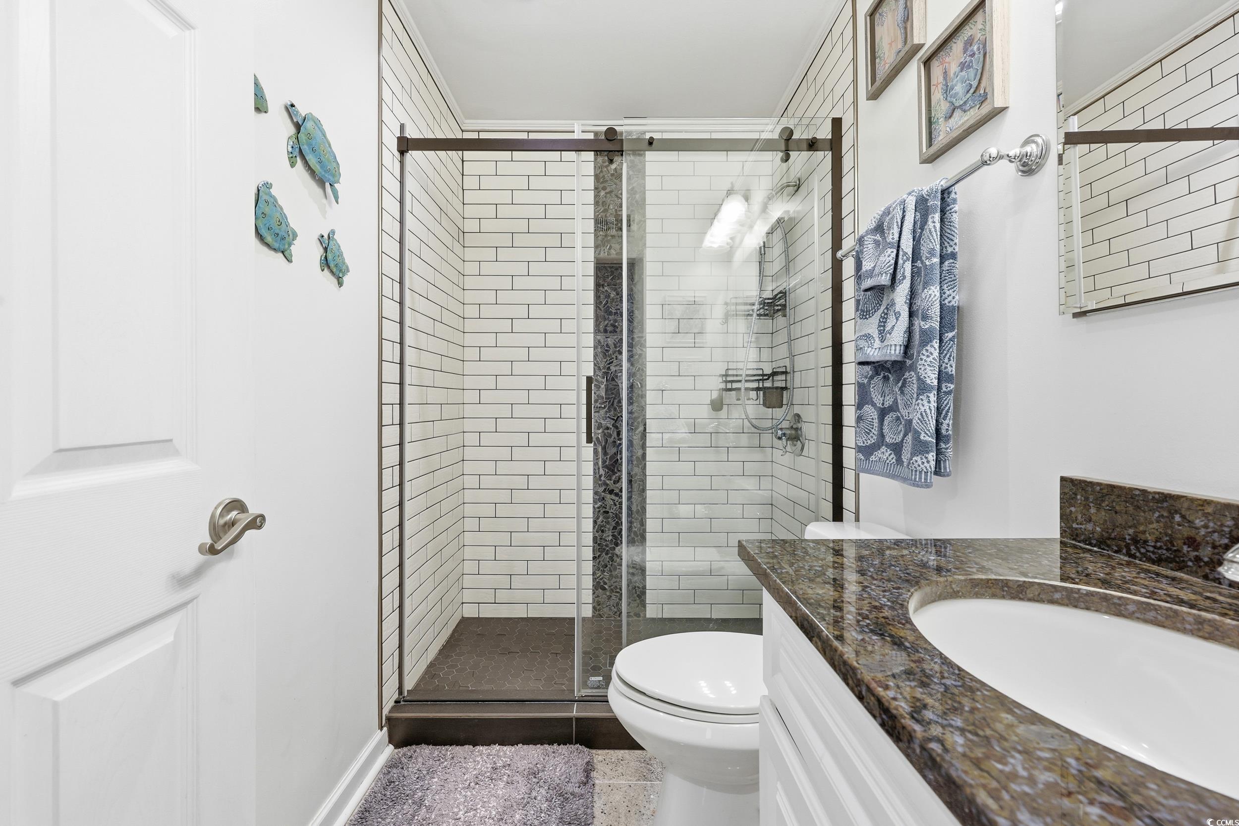 9501 Shore Drive, Unit A208 Myrtle Beach, SC 29572 - Photo 18 of 29 Bathroom with vanity, a shower stall, and dark tile patterned flooring