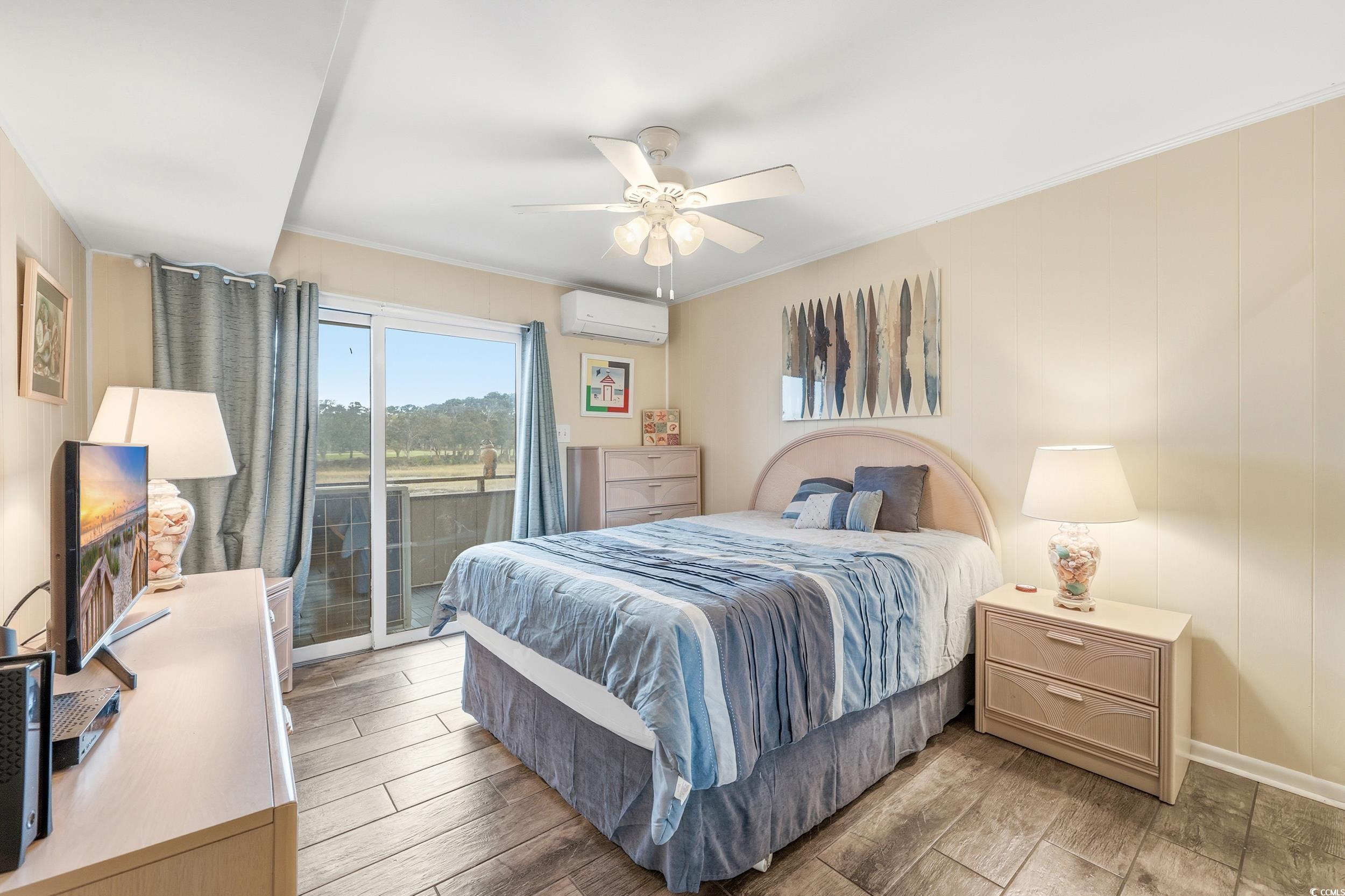 9501 Shore Drive, Unit A208 Myrtle Beach, SC 29572 - Photo 19 of 29 Bedroom featuring wood finish floors, access to exterior, ornamental molding, a ceiling fan, and an AC wall unit