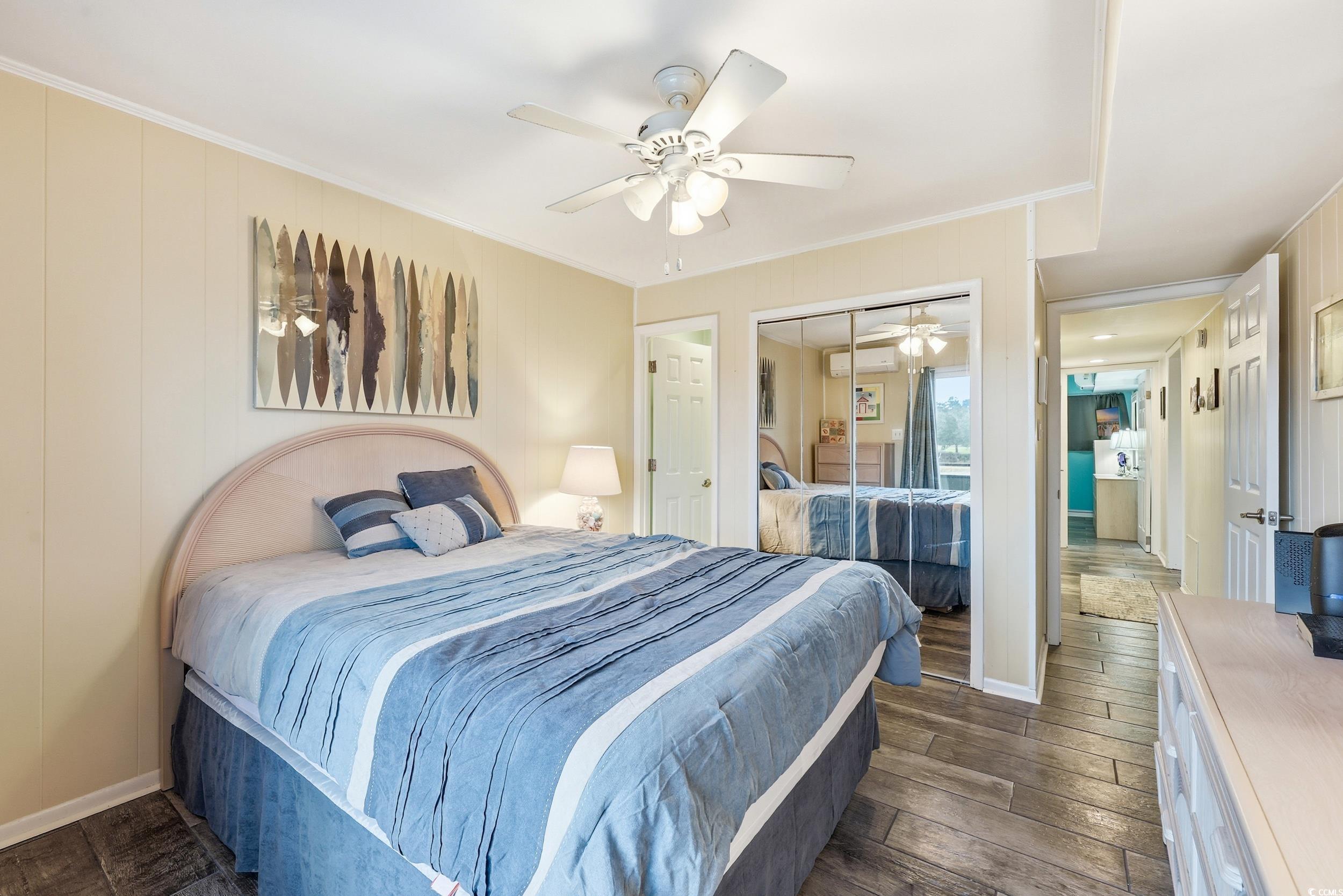 9501 Shore Drive, Unit A208 Myrtle Beach, SC 29572 - Photo 20 of 29 Bedroom with dark wood-style floors, ceiling fan, crown molding, a closet, and a wall unit AC