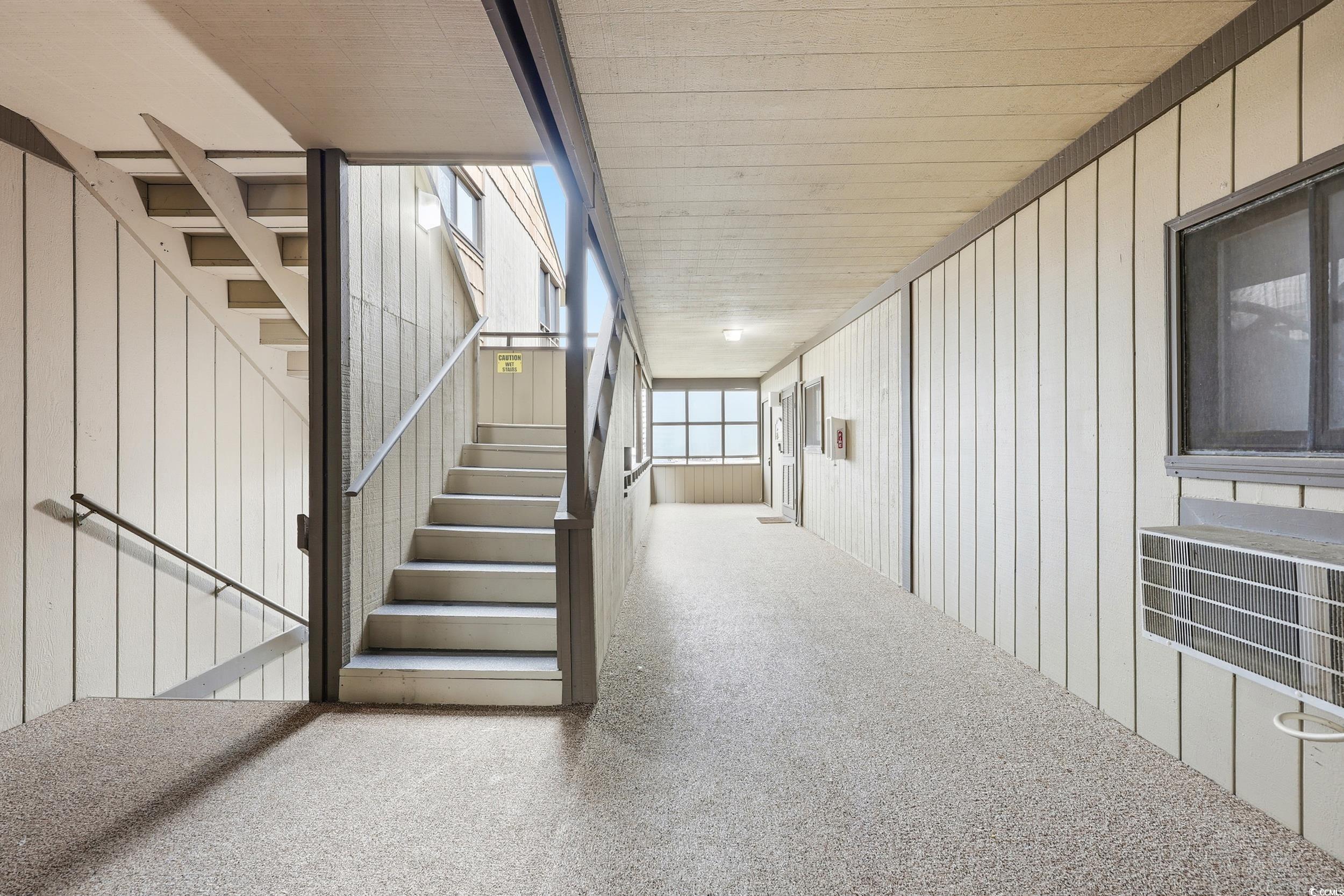 9501 Shore Drive, Unit A208 Myrtle Beach, SC 29572 - Photo 7 of 29 Stairs featuring wood walls, carpet flooring, and wood ceiling