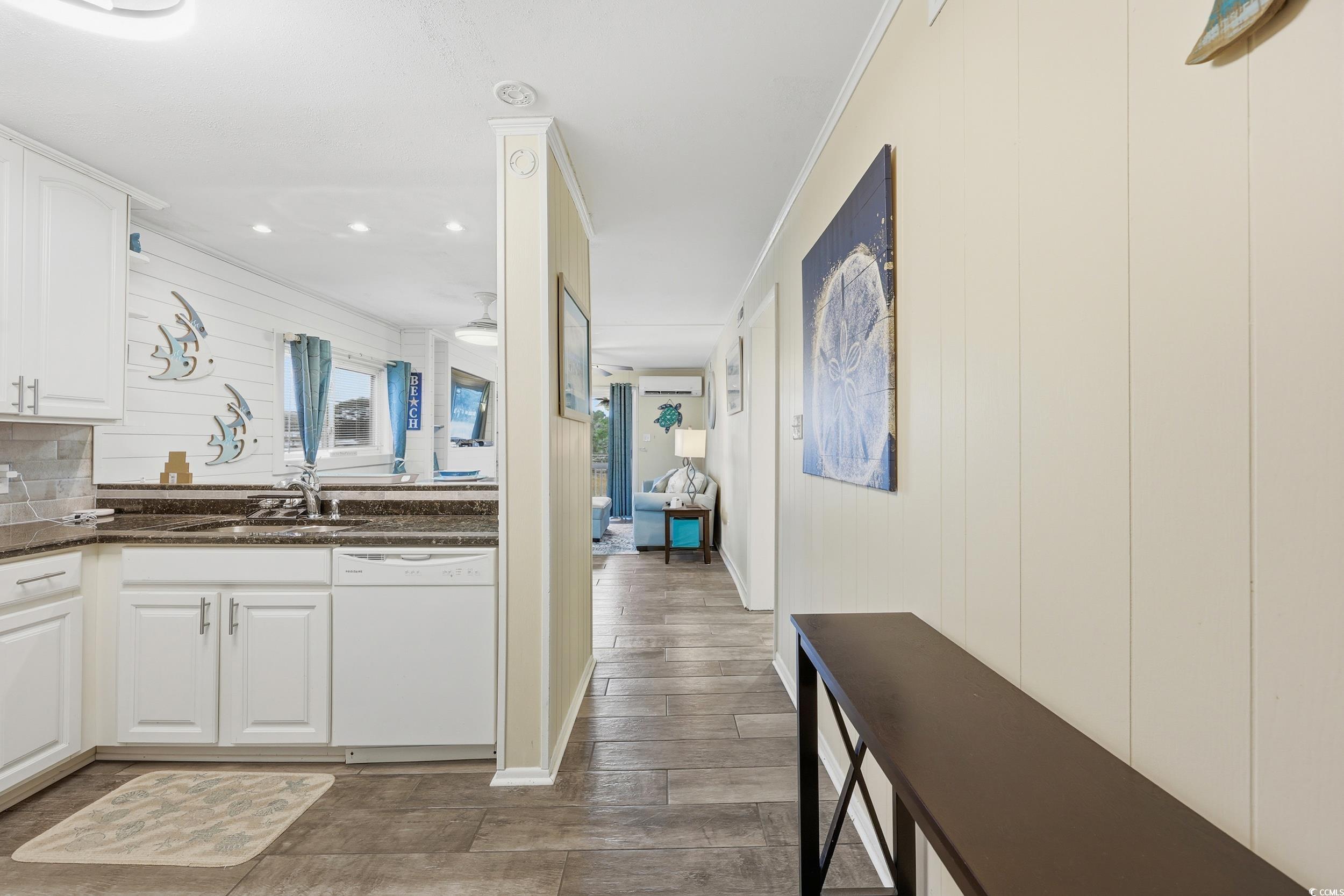 9501 Shore Drive, Unit A208 Myrtle Beach, SC 29572 - Photo 9 of 29 Kitchen featuring white cabinets, dishwasher, dark stone counters, ornamental molding, and wood finish floors